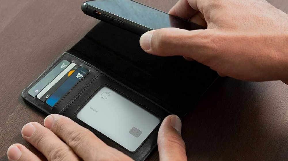 Hands moving an iPhone wallet case around on a table.