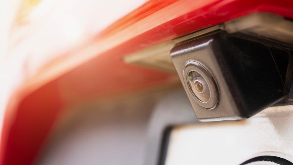 A backup camera installed over a car's license plate.